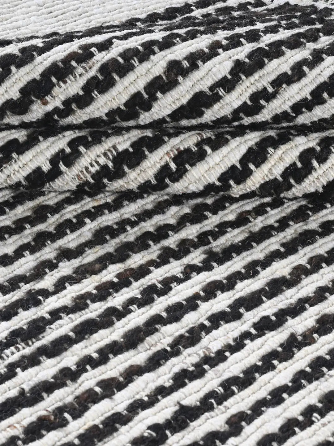 Close-up of a black and white strip woven rug